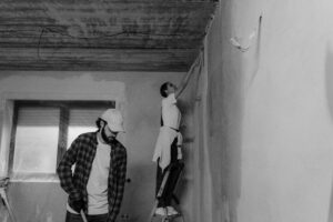 Couple happily painting a room together as a DIY home project